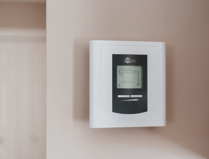 Cost U Less HVAC technician installing a smart thermostat in a home