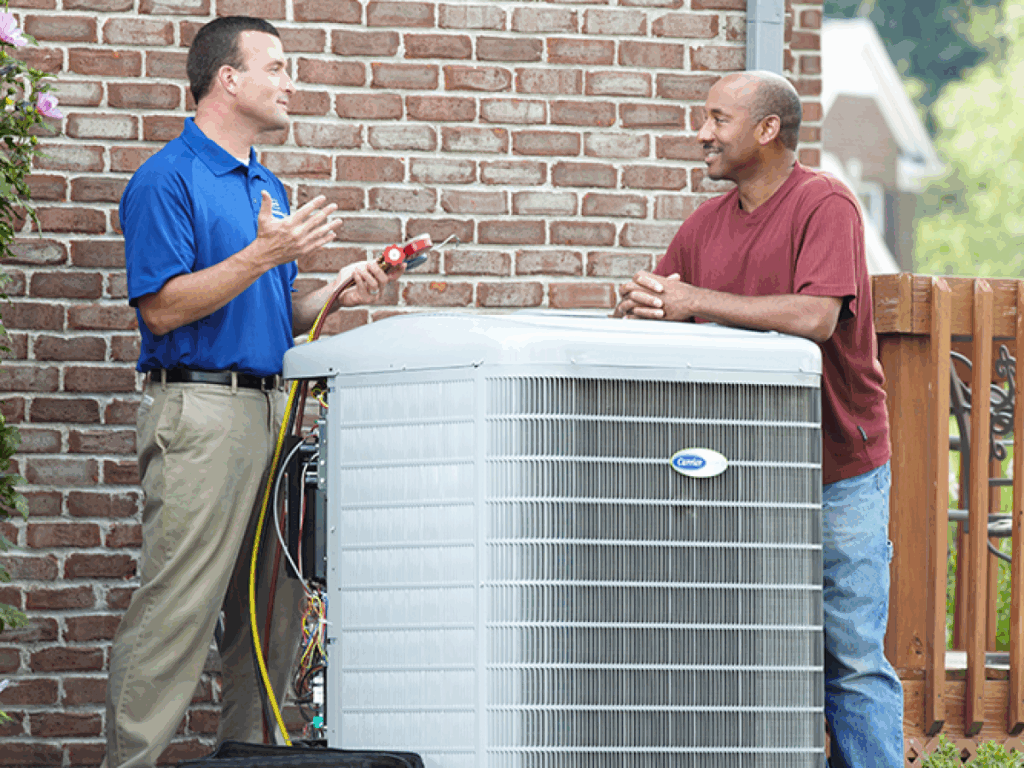 HVAC technician performing air conditioning repair at a home
